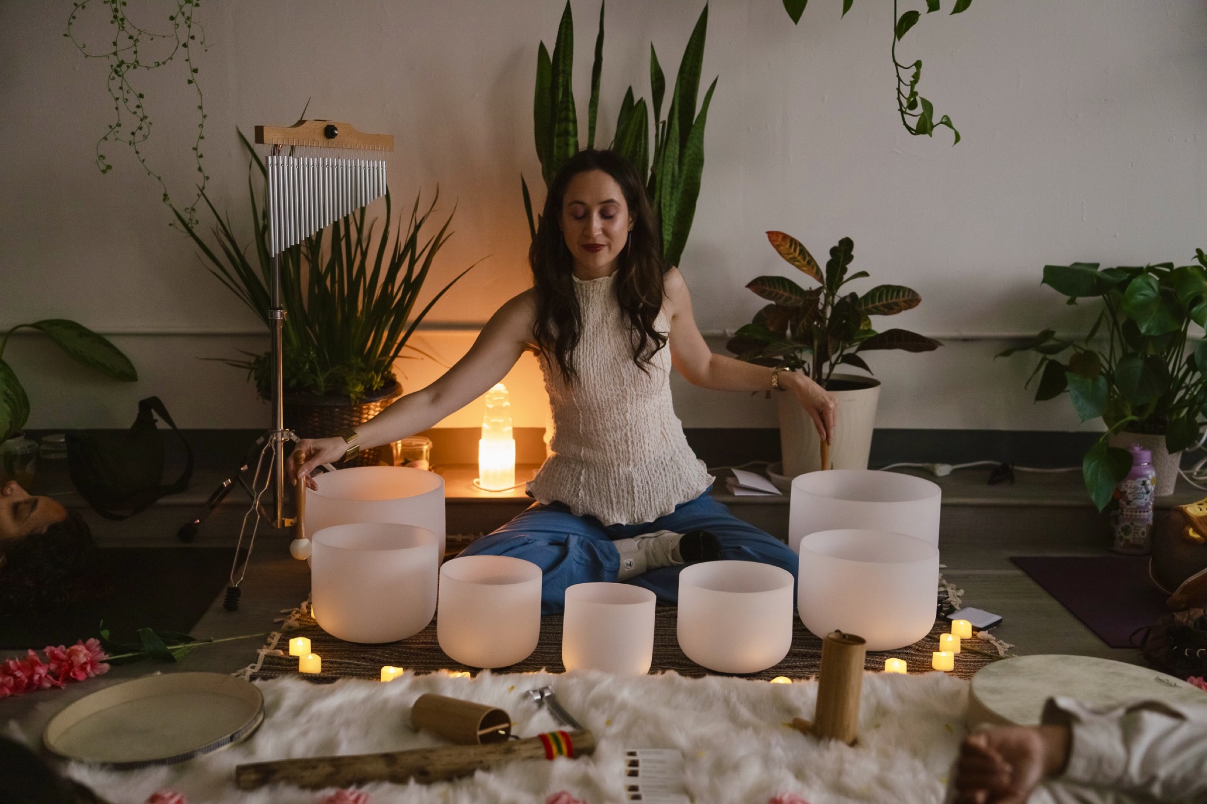 Desiree in warm candlelight surrounded by singing bowls, part of the real Mindfulness with Desiree brand photography