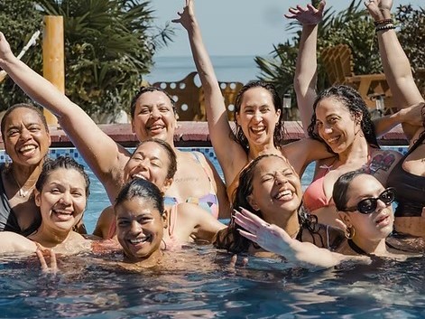 Women celebrating together in a pool at one of Desiree's retreats