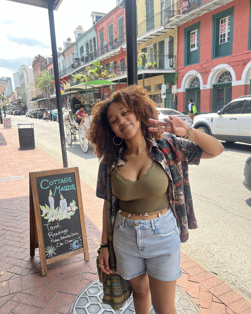 Kymari making a peace sign on a colorful street in the French Quarter, New Orleans